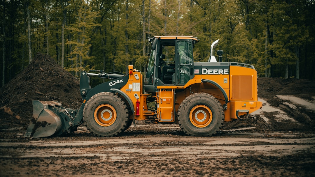 our-story a-tractor-is-parked-in-the-dirt-near-a-pile-of-dirt-kormf1nz8iw
