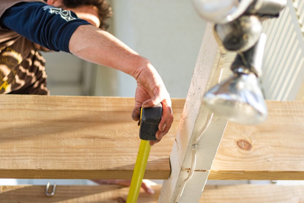 A builder measures out the gap between each beam