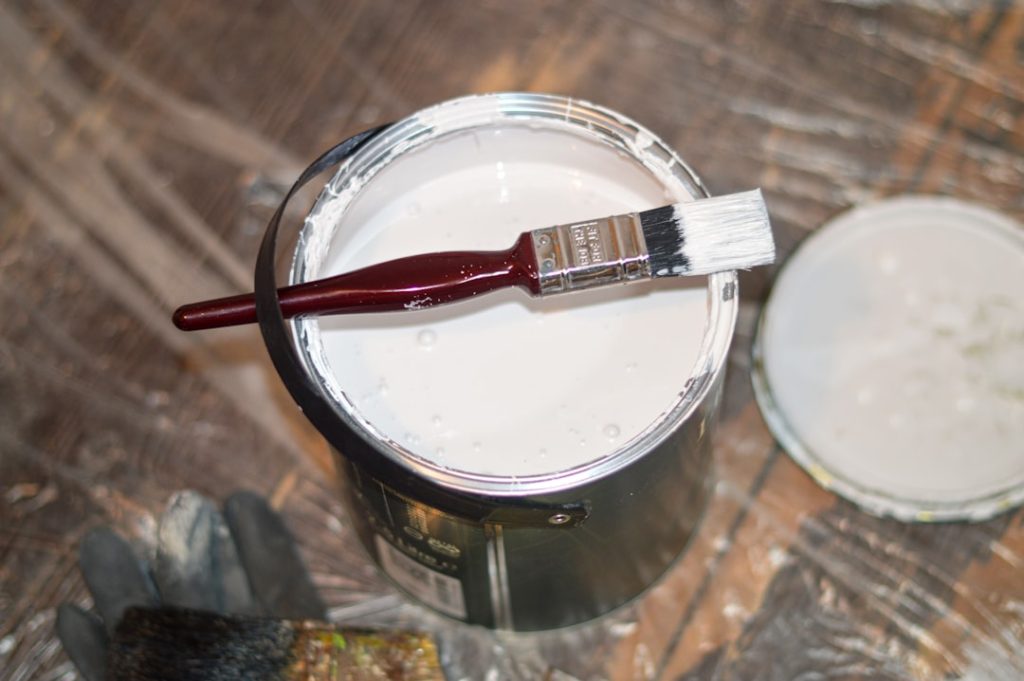 red-handle-paint-brush-in-white-paint-bucket-dw5fyca8kfs tin of white paint with brush
